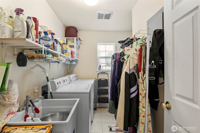 laundry area featuring laundry area, light tile patterned floors, visible vents, independent washer and dryer, and a sink
