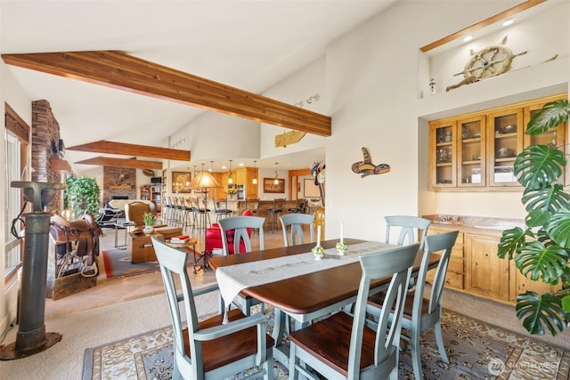 carpeted dining area with high vaulted ceiling