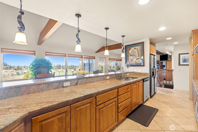 kitchen with brown cabinetry, a sink, refrigerator with ice dispenser, and dishwasher