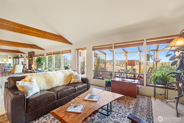 living area featuring lofted ceiling with beams, a sunroom, and carpet flooring