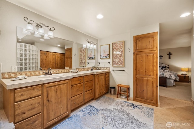 ensuite bathroom featuring recessed lighting, a sink, ensuite bath, and double vanity