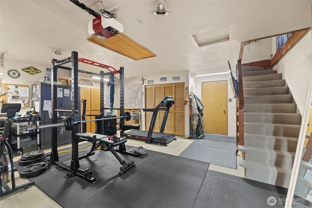 exercise area with attic access and a textured ceiling