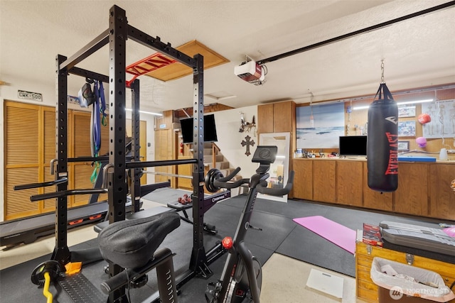 workout area featuring a garage and a textured ceiling