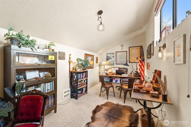 carpeted office space featuring lofted ceiling and a textured ceiling