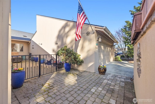 exterior space featuring a garage, decorative driveway, and fence