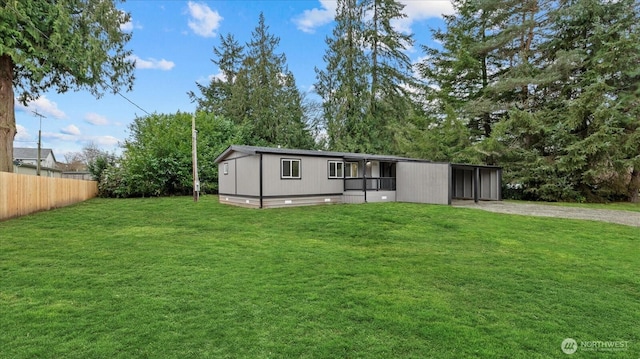 view of front of property with driveway, fence, and a front lawn