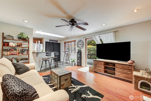 living room with baseboards, wood finished floors, and recessed lighting