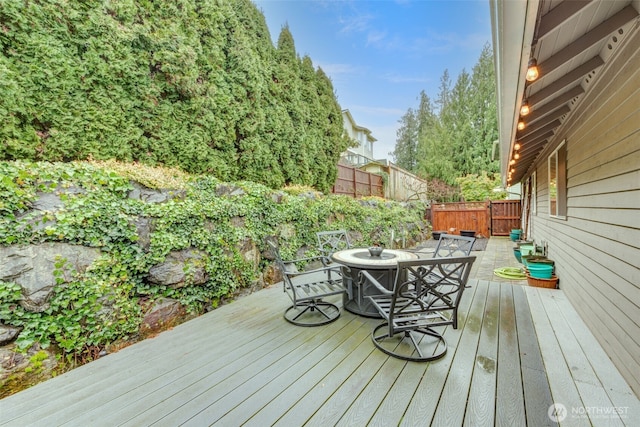 wooden deck with outdoor dining area and fence