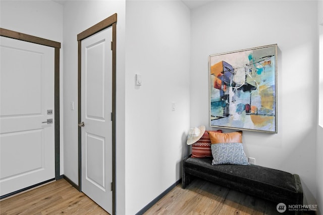 hall featuring light wood-style floors and baseboards