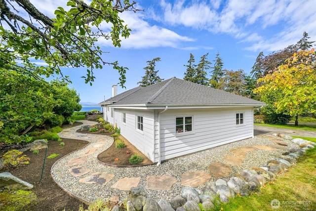 view of side of property with a shingled roof