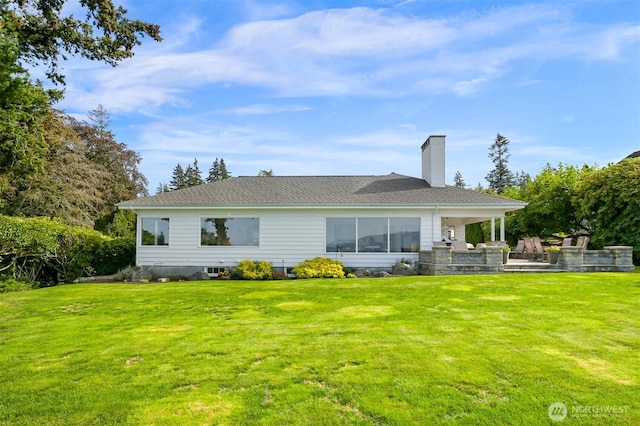 back of house featuring a patio, a lawn, and a chimney