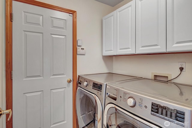 washroom with washing machine and dryer and cabinet space