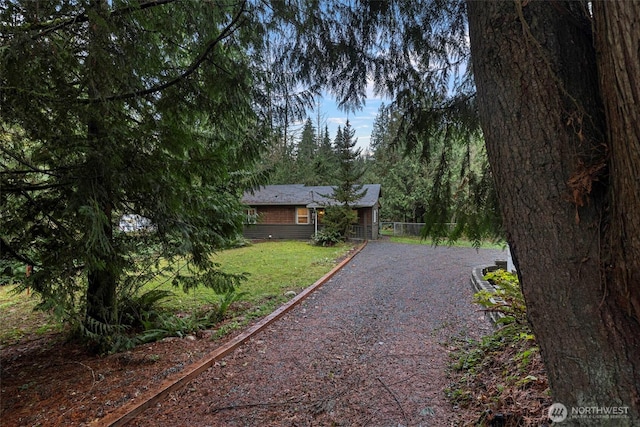 view of front of home with a front yard and gravel driveway