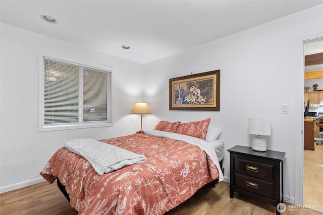 bedroom featuring baseboards, wood finished floors, and recessed lighting