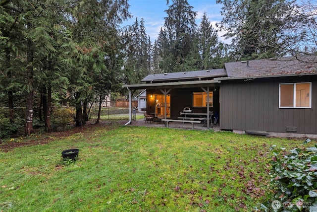 back of property with crawl space, a patio area, fence, and a lawn