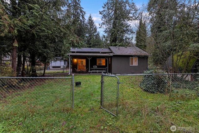 view of front of house with crawl space, a fenced backyard, a front lawn, and solar panels