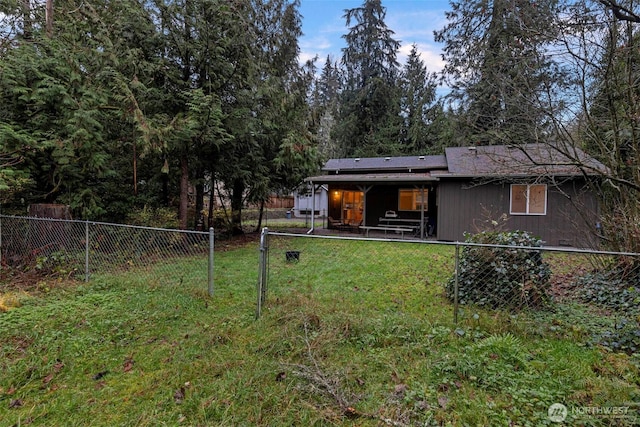 rear view of house with a fenced backyard, a yard, and a patio