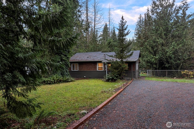 ranch-style home with fence, driveway, and a front lawn