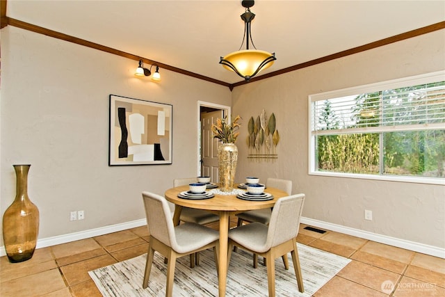 dining space featuring light tile patterned floors, baseboards, visible vents, and crown molding