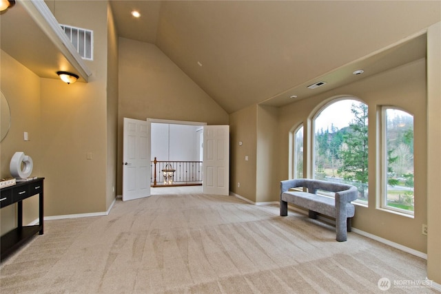 interior space featuring carpet floors, high vaulted ceiling, baseboards, and visible vents