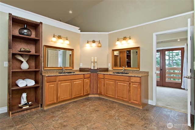 full bath with ornamental molding, two vanities, and a sink