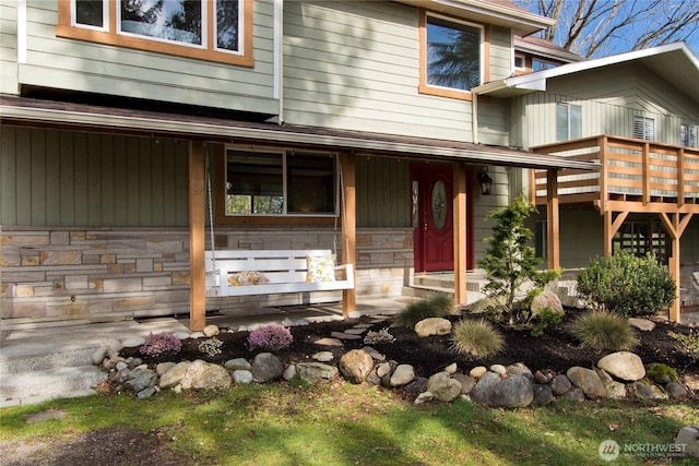 doorway to property with stone siding and covered porch