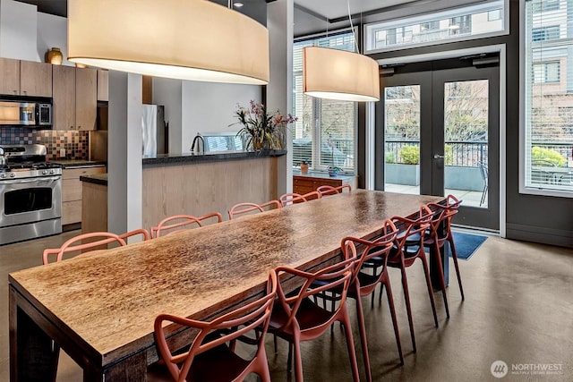 dining space featuring french doors and concrete floors