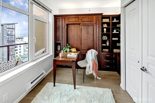 home office with dark wood-type flooring, baseboard heating, and baseboards