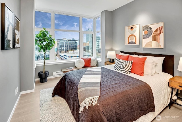 bedroom featuring a baseboard radiator, wood finished floors, and baseboards