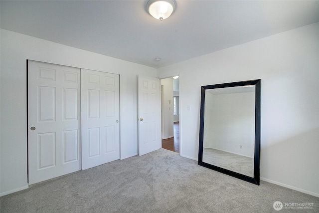 unfurnished bedroom featuring a closet, carpet flooring, and baseboards