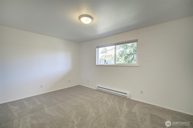 empty room featuring carpet floors, a baseboard radiator, and baseboards