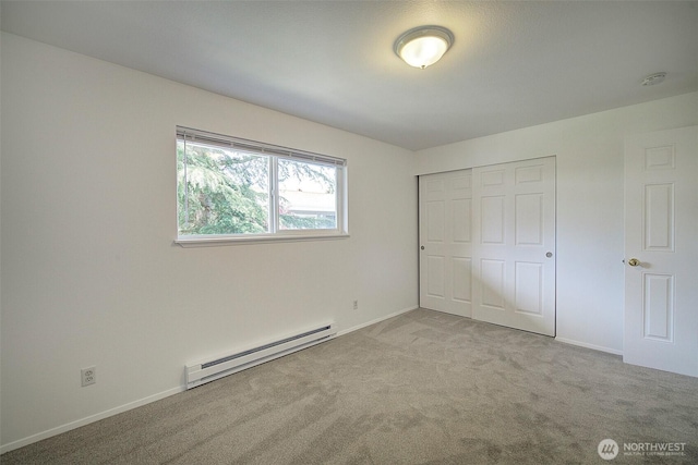 unfurnished bedroom featuring baseboards, carpet, a baseboard heating unit, and a closet