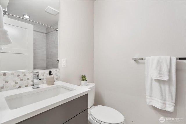 full bath with tasteful backsplash, toilet, and vanity