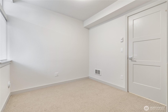 carpeted spare room with visible vents and baseboards