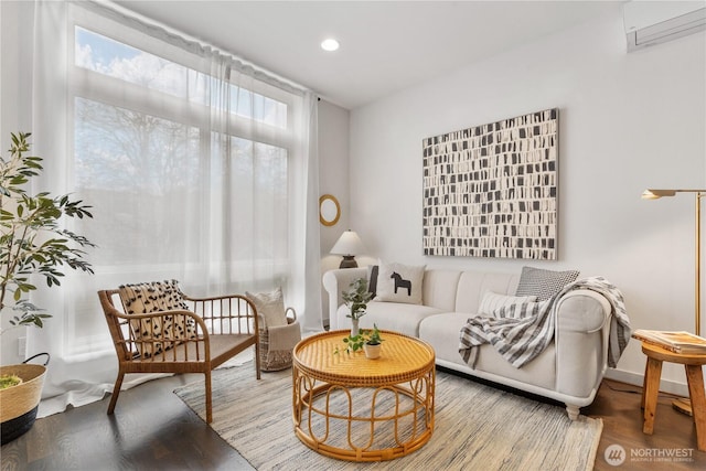 living area with recessed lighting, a wall unit AC, and wood finished floors