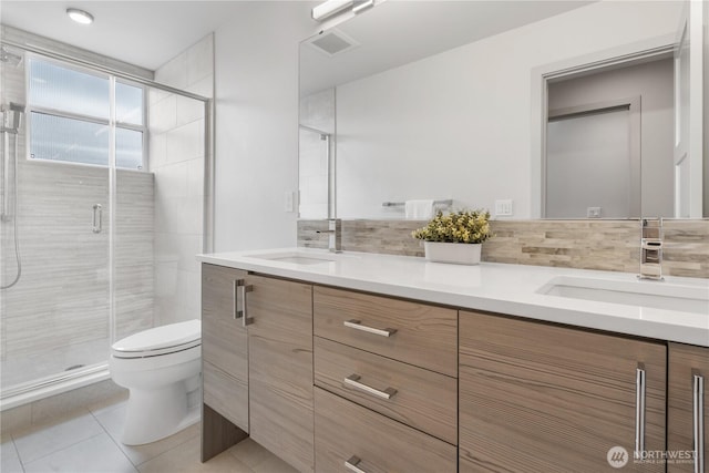 full bathroom featuring a shower stall, toilet, visible vents, and a sink