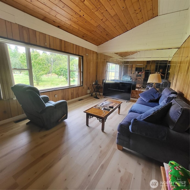 living area with light wood finished floors, visible vents, wood ceiling, vaulted ceiling, and wood walls