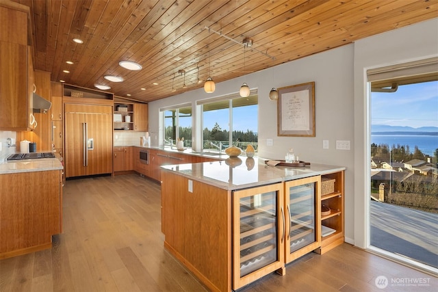 kitchen with brown cabinetry, beverage cooler, paneled refrigerator, and open shelves