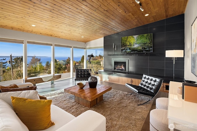 living area with recessed lighting, wood ceiling, vaulted ceiling, and a tiled fireplace