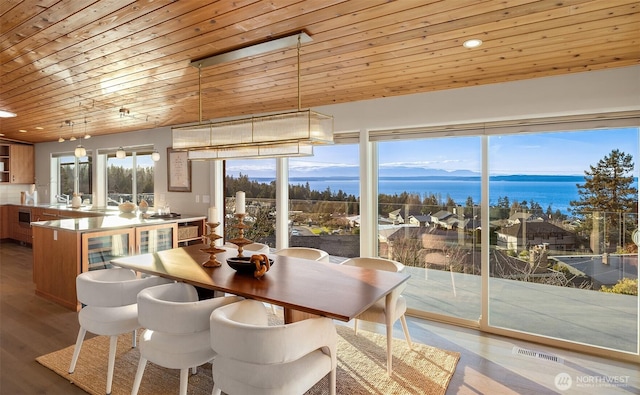 dining space with wood ceiling, wine cooler, wood finished floors, a mountain view, and recessed lighting