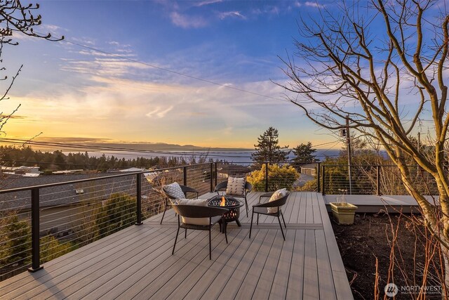 deck featuring a fire pit and a water view