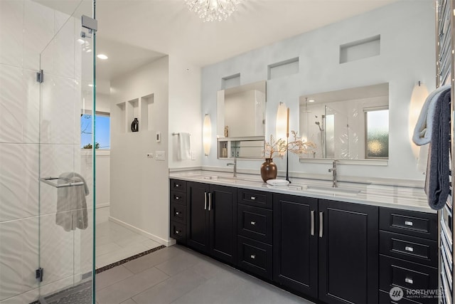 bathroom with double vanity, a stall shower, tile patterned flooring, and a sink