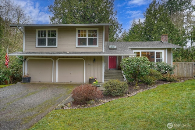 view of front of home featuring roof with shingles, a chimney, a front yard, fence, and driveway