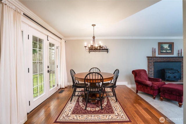 dining room featuring plenty of natural light, ornamental molding, dark wood-type flooring, and french doors