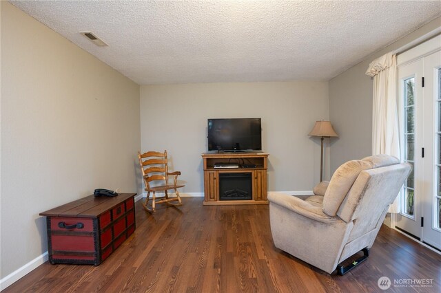 living area with a fireplace, wood finished floors, a wealth of natural light, and baseboards