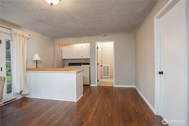 kitchen featuring a textured ceiling, dark wood finished floors, visible vents, and white cabinetry