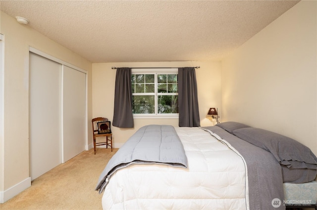 bedroom featuring carpet floors, a textured ceiling, and a closet