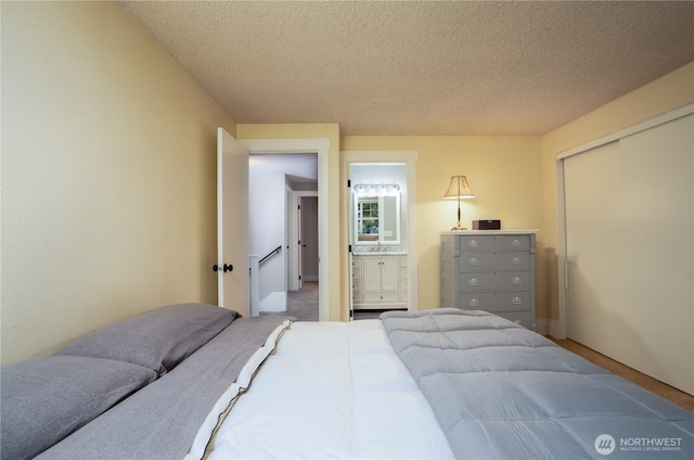 bedroom featuring a textured ceiling, a closet, and connected bathroom