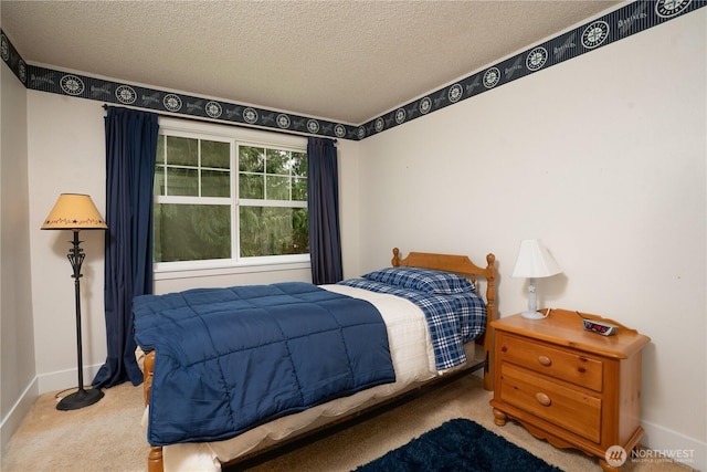 bedroom with a textured ceiling, carpet flooring, and baseboards