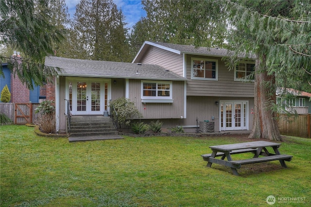 rear view of house featuring a yard, french doors, and fence